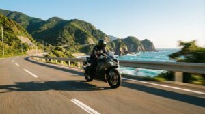 海岸沿いの道路を走行する黒い250ccスポーツバイク